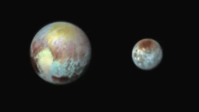 Pluto, on the left, and its moon Charon, on the right, in false colour, photographed by New Horizons