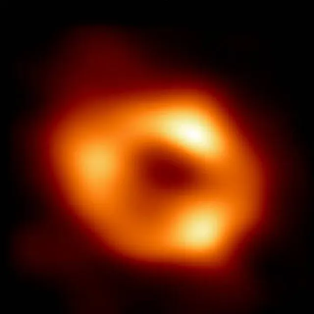 The first image of Sagittarius A*: an orange ring of bright gas around a dark shadow, from the Event Horizon Telescope