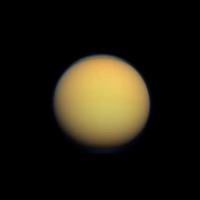 Titan, an orange sphere blurred by its thick atmosphere, in natural colour, photographed by Cassini