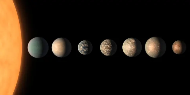 NASA illustration of the seven TRAPPIST-1 planets in a row beside their star; it is not a photo