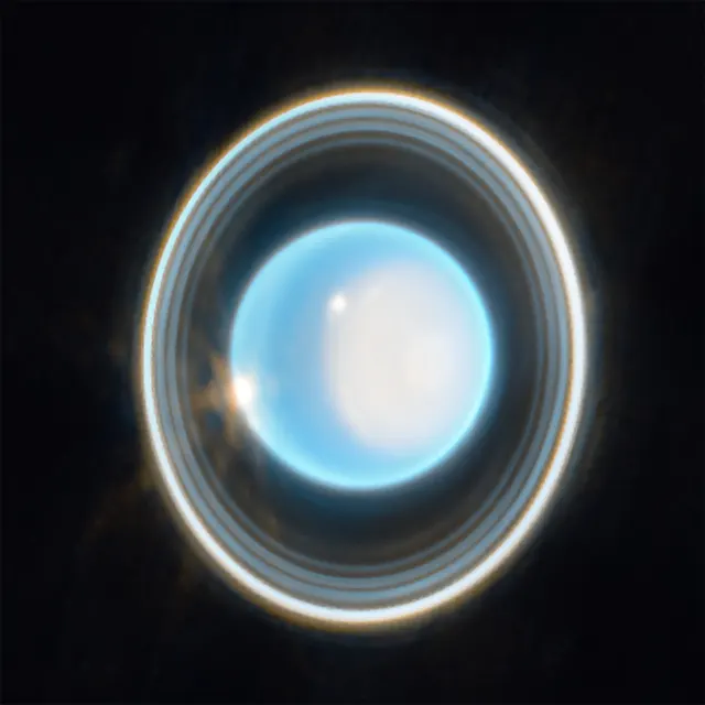 Uranus, pale blue, with its thin rings around it, photographed by the James Webb telescope